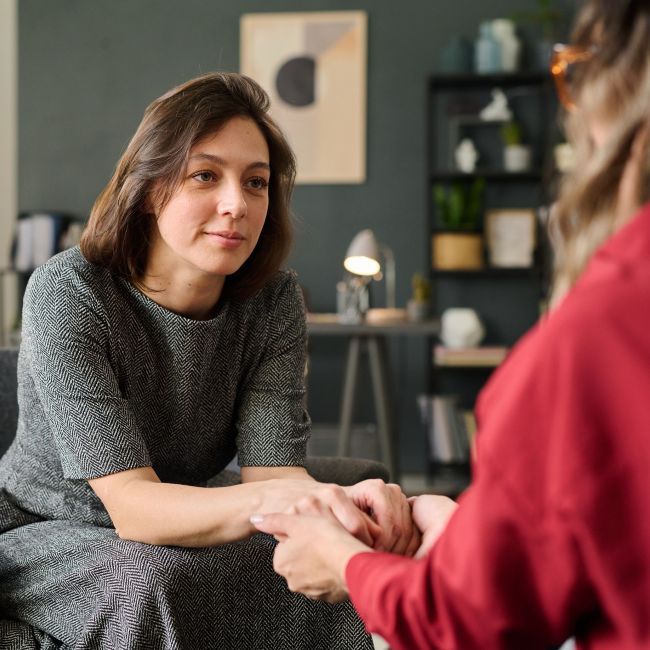 Osoba okazuje wsparcie bliskiej osobie podczas rozmowy o zdrowiu psychicznym. Empatyczna komunikacja i obecność pomagają w radzeniu sobie z trudnościami emocjonalnymi.